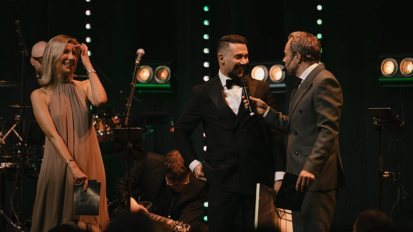 Intervju på scen under Guldhemmet-galan där programledare samtalar med vinnare inför publik och scenljus i bakgrunden