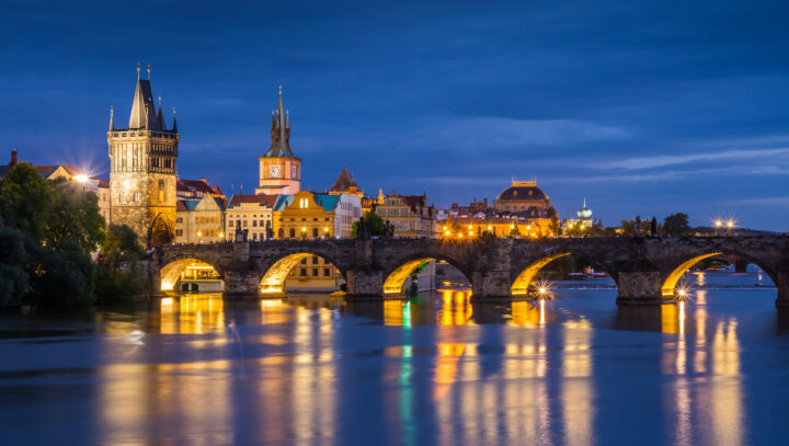 Kvadrat i Prag. Karlsbron över floden Vltava i Prag under en blå kvällshimmel.