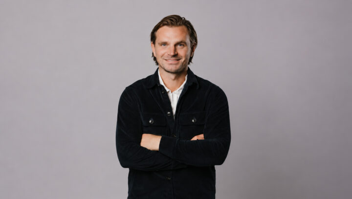 Niklas Åström, vd och grundare av K&E Studios, med armarna i kors framför en grå bakgrund.